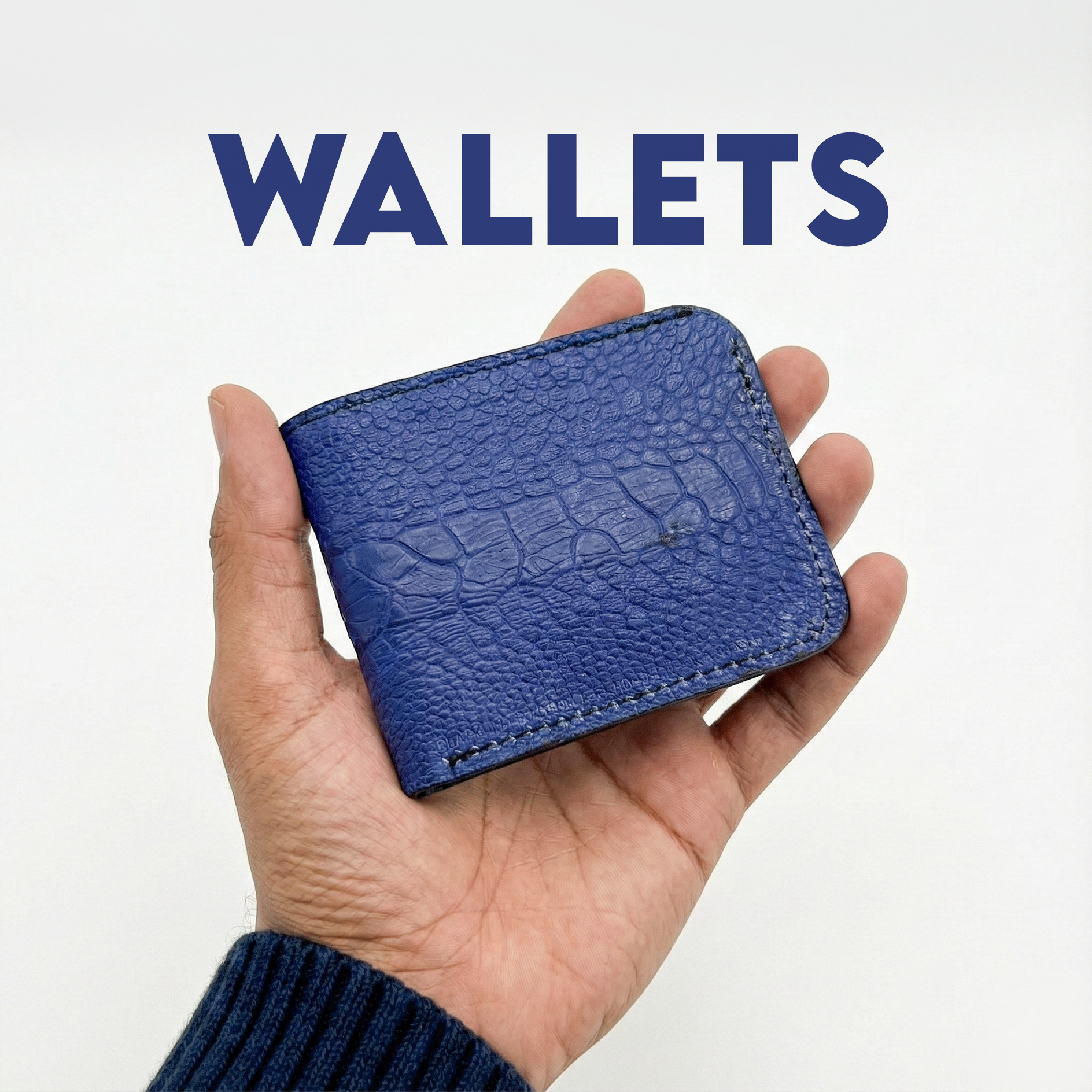 A hand holds a textured blue wallet against a plain white background. The word "WALLETS" is prominently displayed above in bold blue letters, conveying simplicity.