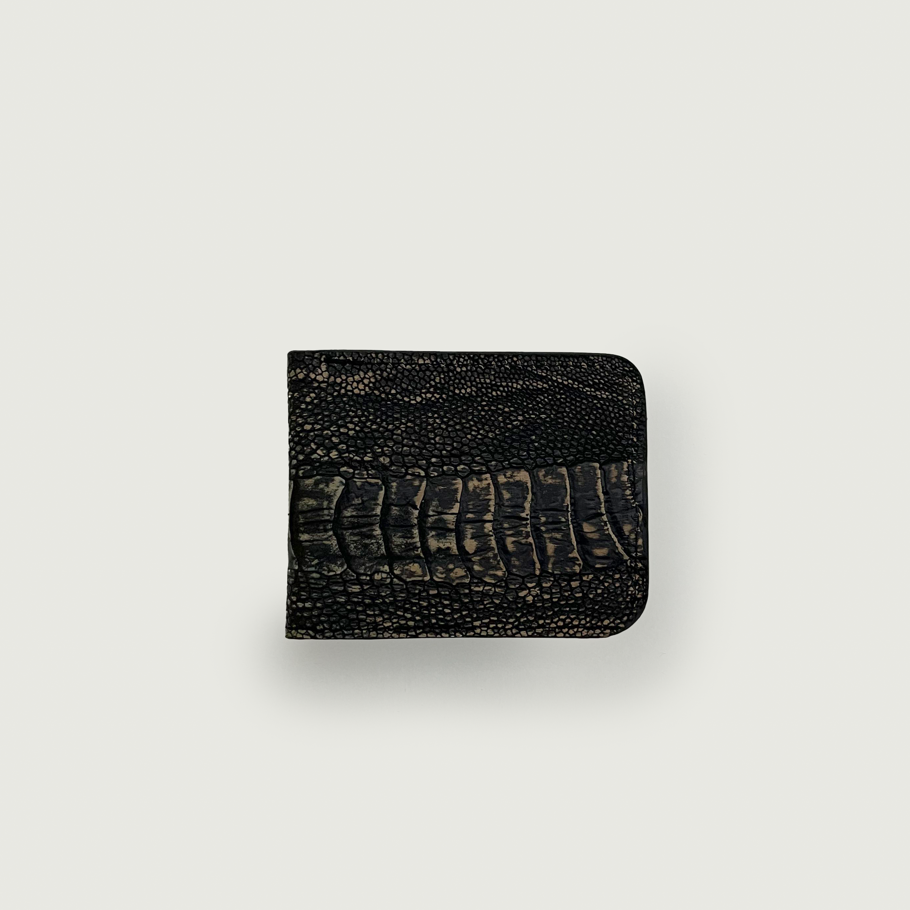 A dark crocodile-textured wallet is centered against a light gray background. The texture suggests luxury and sophistication, conveying a sense of elegance.